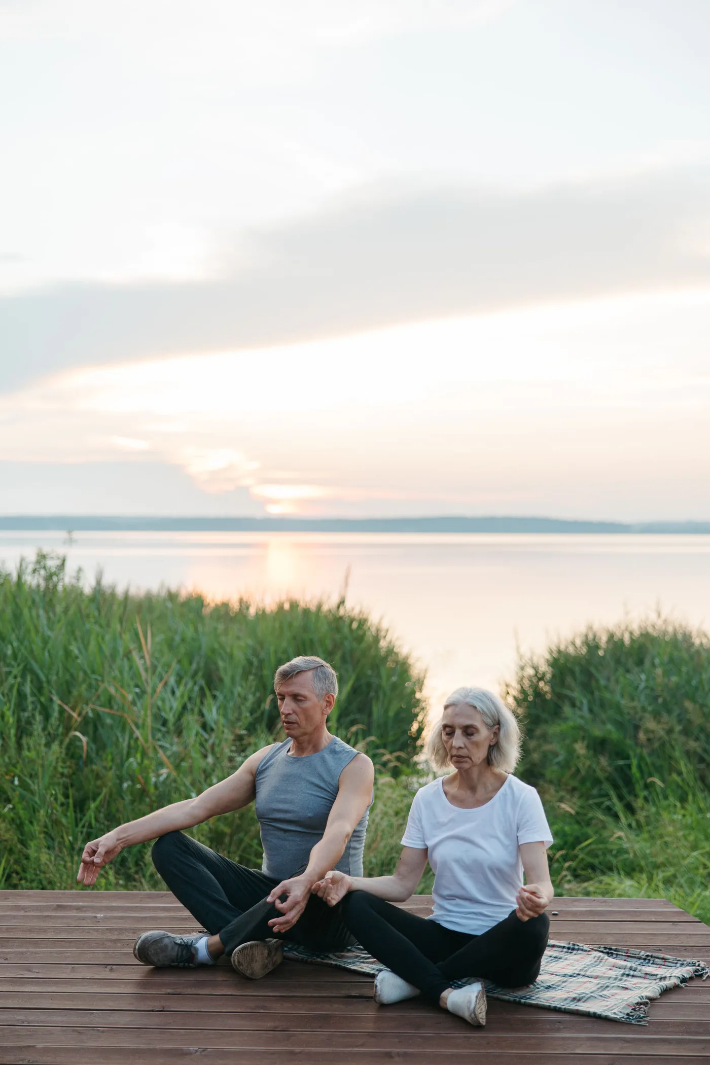 Couple practising wellness beside a peaceful lake